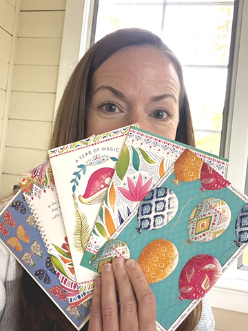 Michele holding a fan of her licensed greeting cards